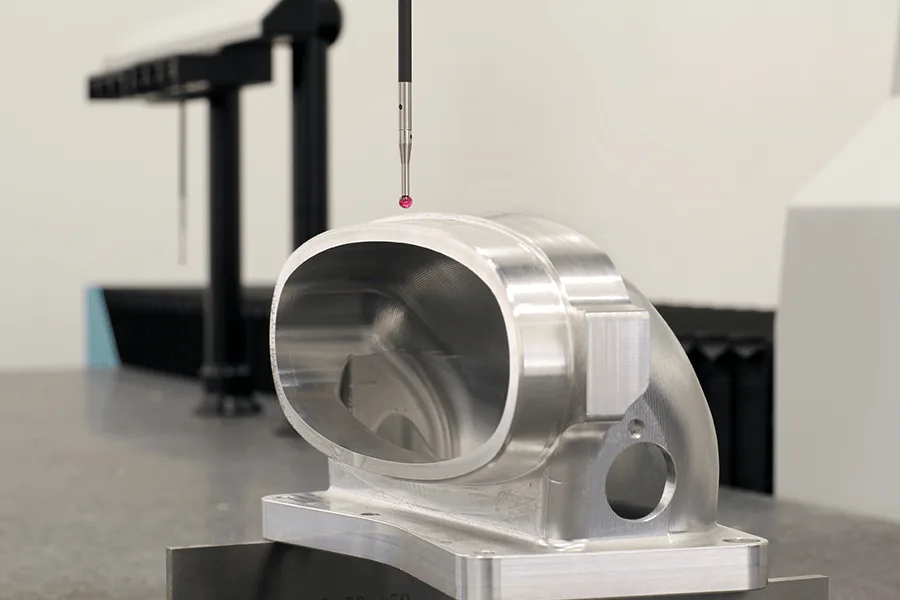 Precision measurement of a machined aluminum component using a coordinate measuring machine (CMM) at Formkon